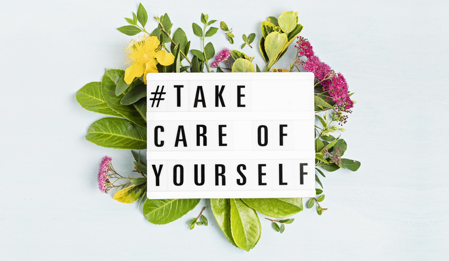 flowers with white sign that says take care of yourself