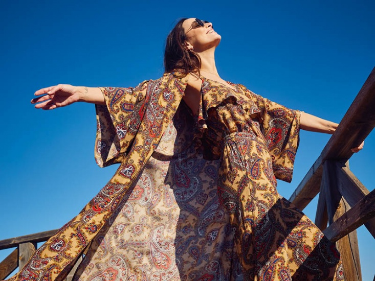 Woman stood arms open looking up to the sun