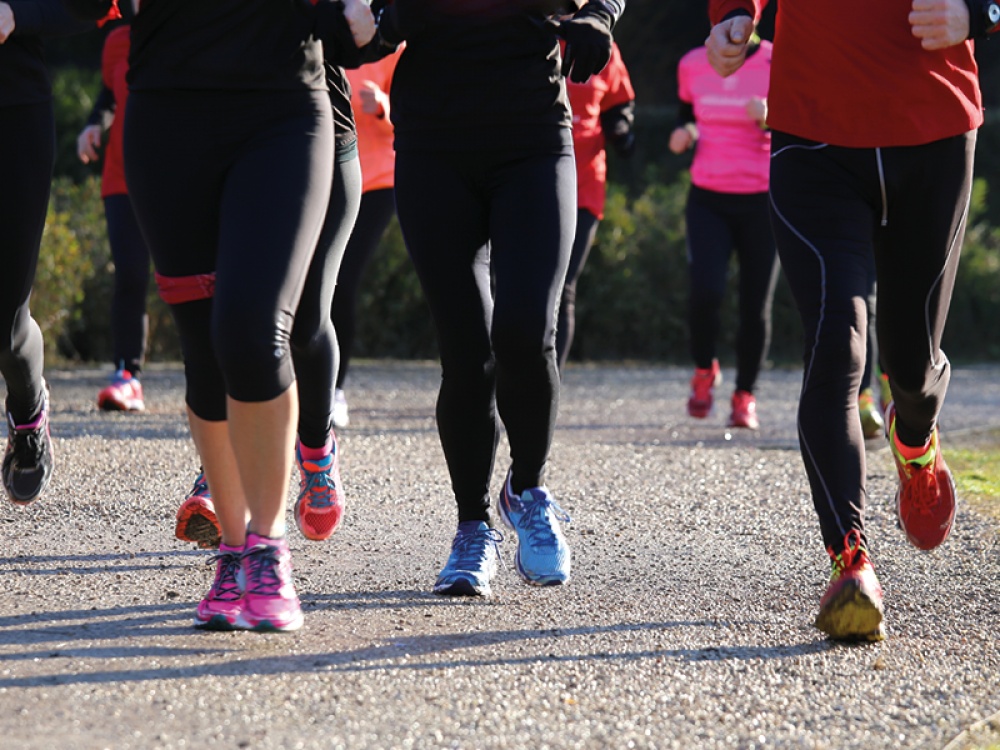 a group of runners, running together, image only showing their legs