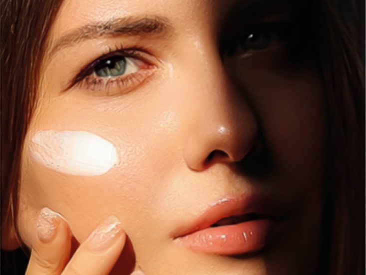 Model with cream on cheekbone