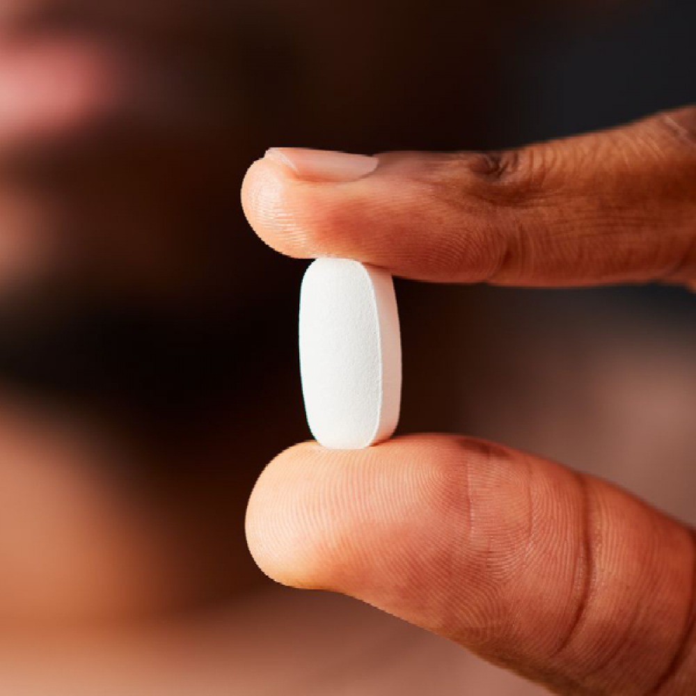 magnesium tablet being held between finger and thumb