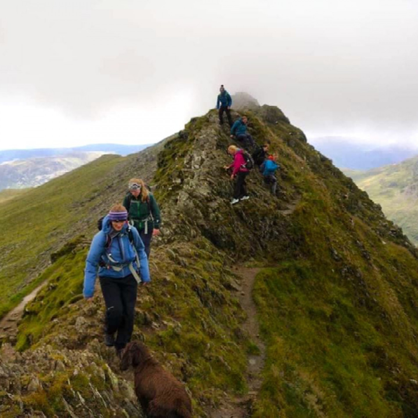 women walking across the top of a mountain