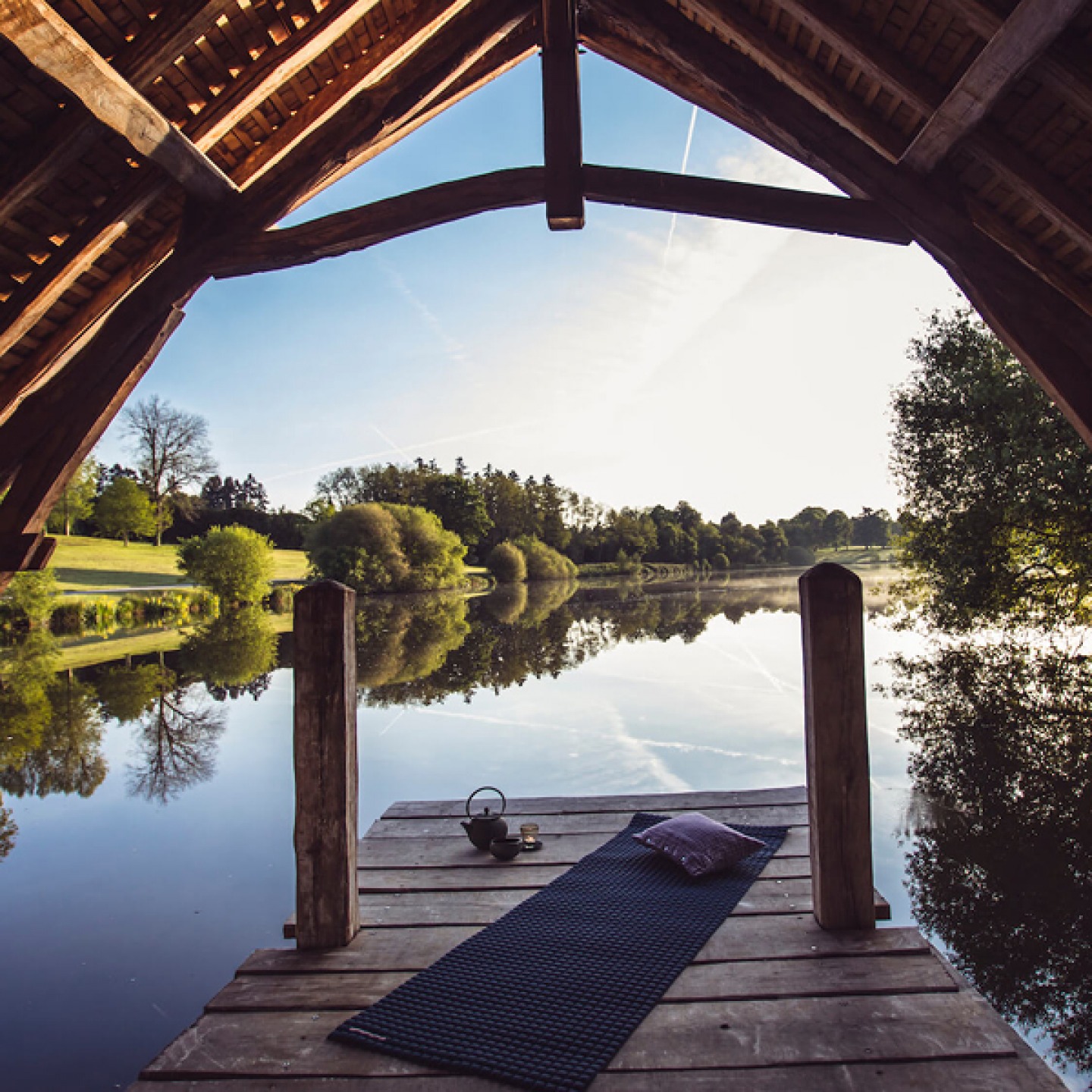Covered Wooden jetty with exercise mat overlooking tranquil lake