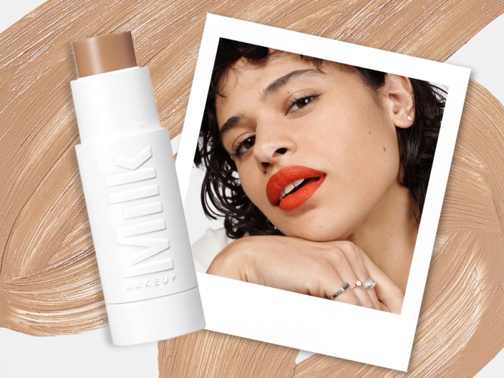 MILK Makeup Flex Foundation Stick with a Polaroid of a woman wearing the foundation