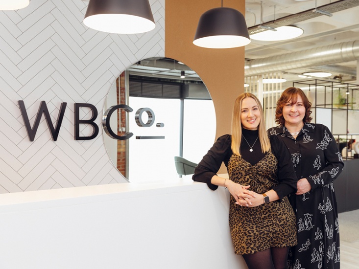 Kim Cattin and Donna McCann-Turner standing at the front desk of their office