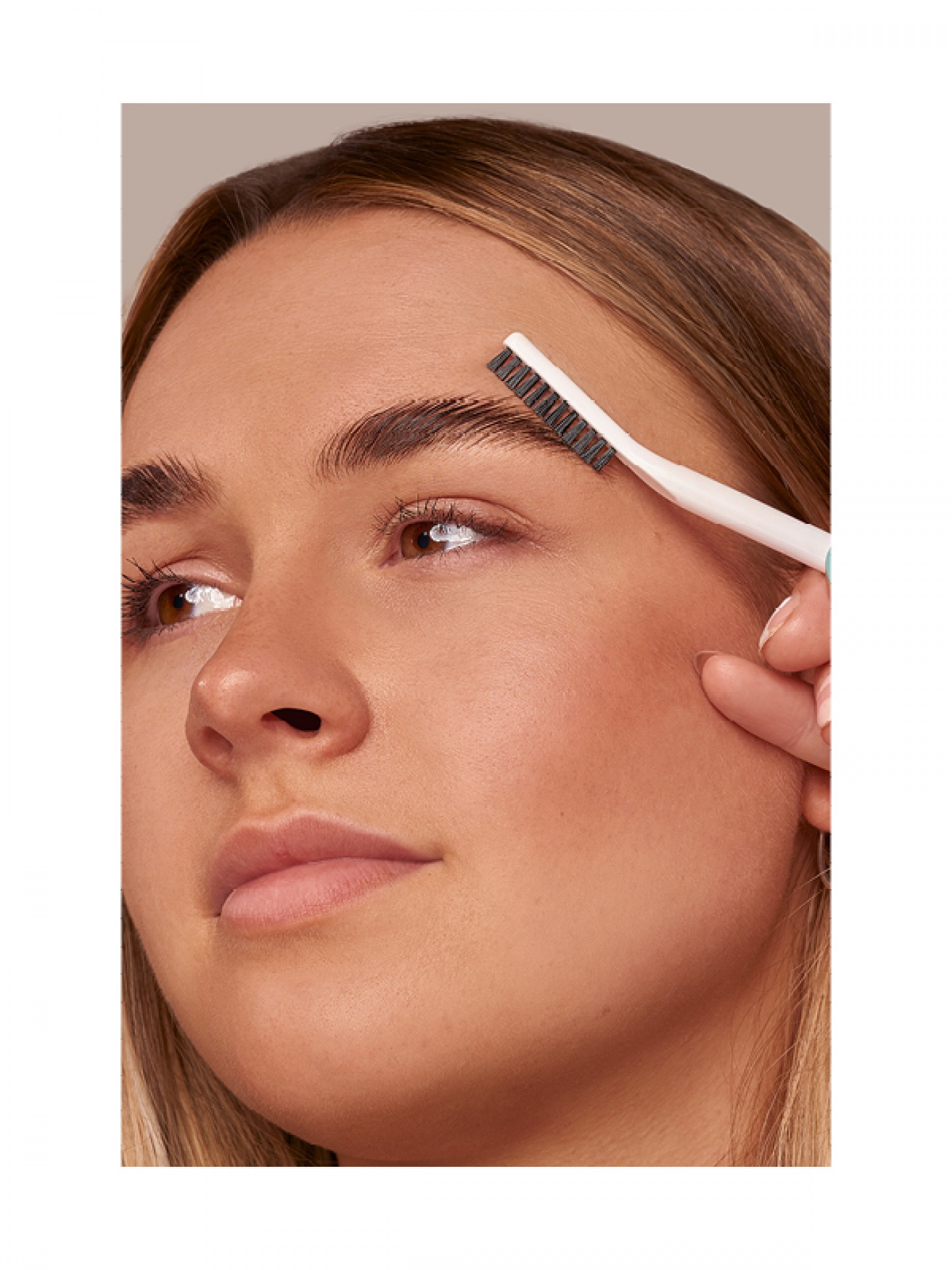 woman brushing eyebrows