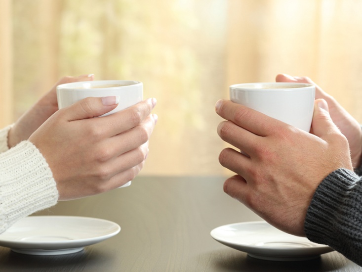 two hands holding coffee cups