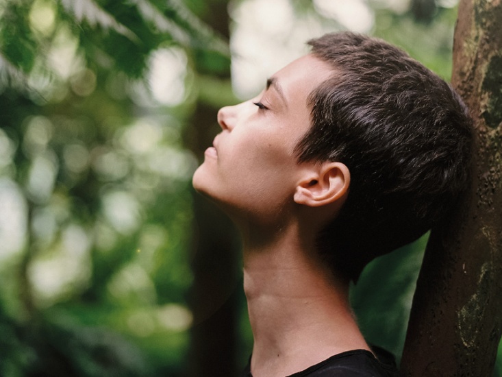 woman leaning on a tree