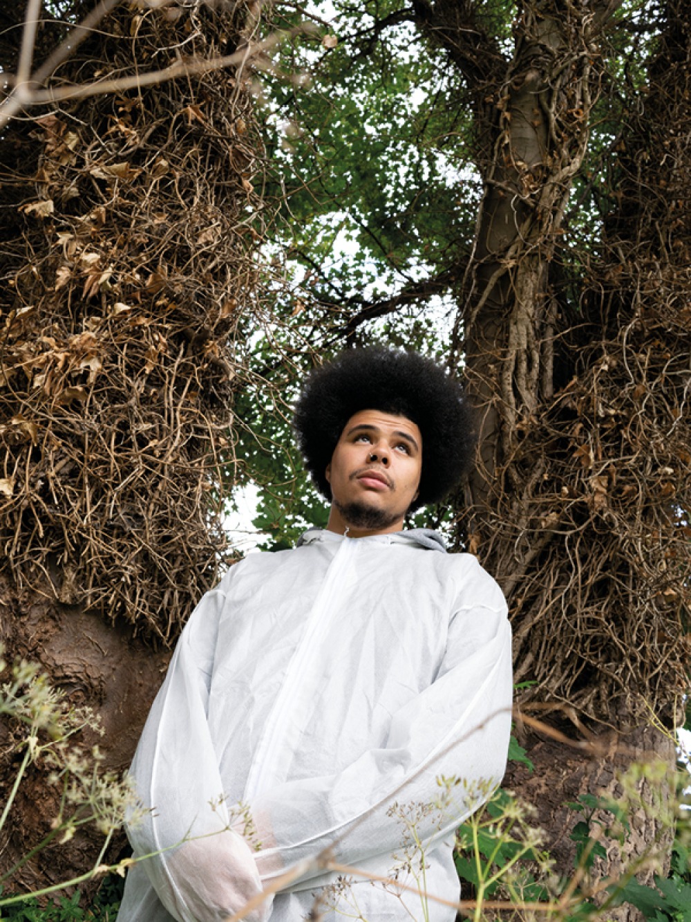 Otis Mensah photographed infront of vines and trees