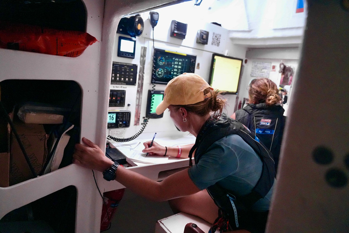 Sailors aboard yachts inside comms cabin during Clipper race