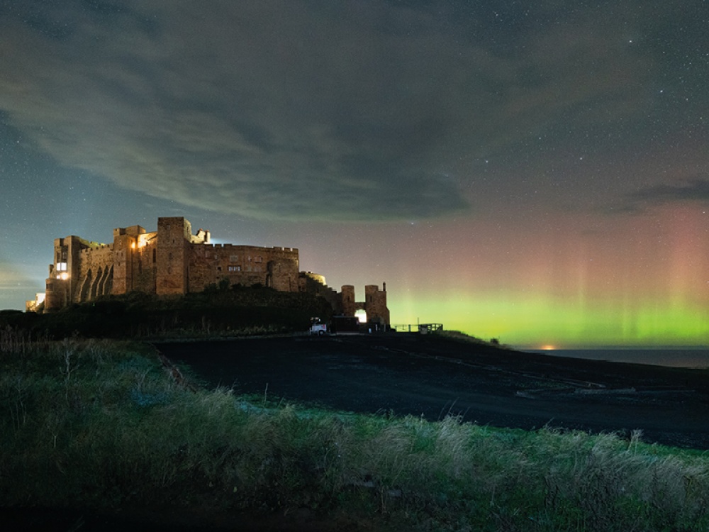 Castle on the coast with Northern Lights over the sea