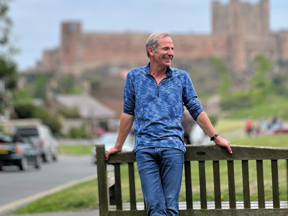 man leaning on a bench outside a castle
