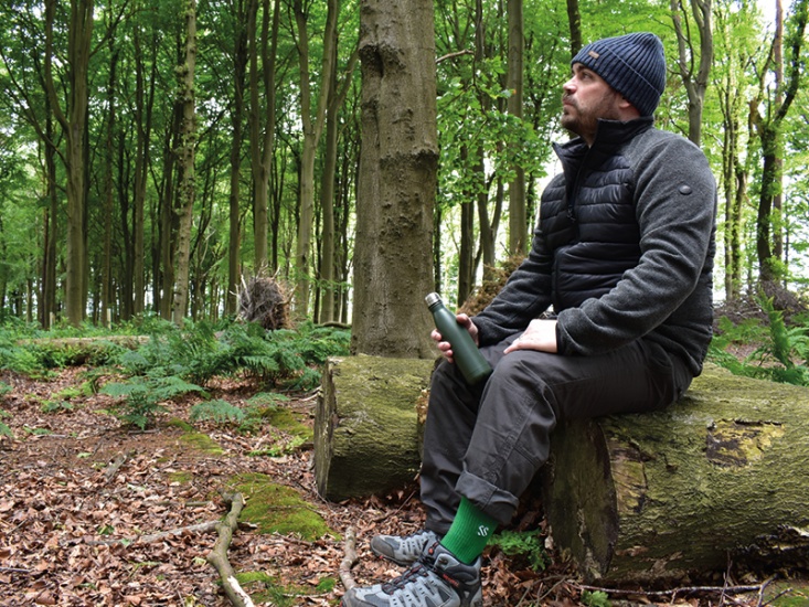 Man on a walk in woodland taking a break