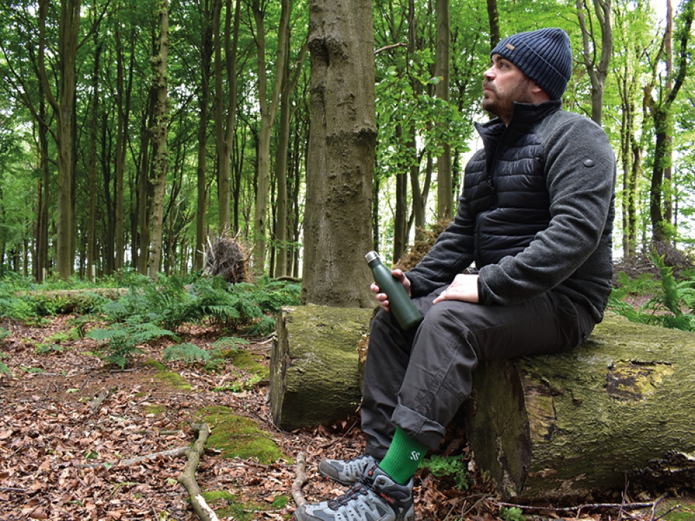 Man on a walk in woodland taking a break