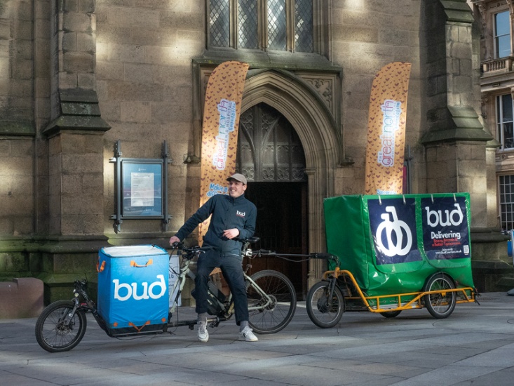 Man perched on his bicycle promoting his bike courier service