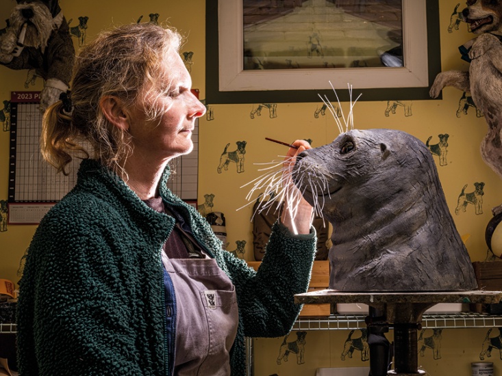 A Sculptor painting their artwork of a seal