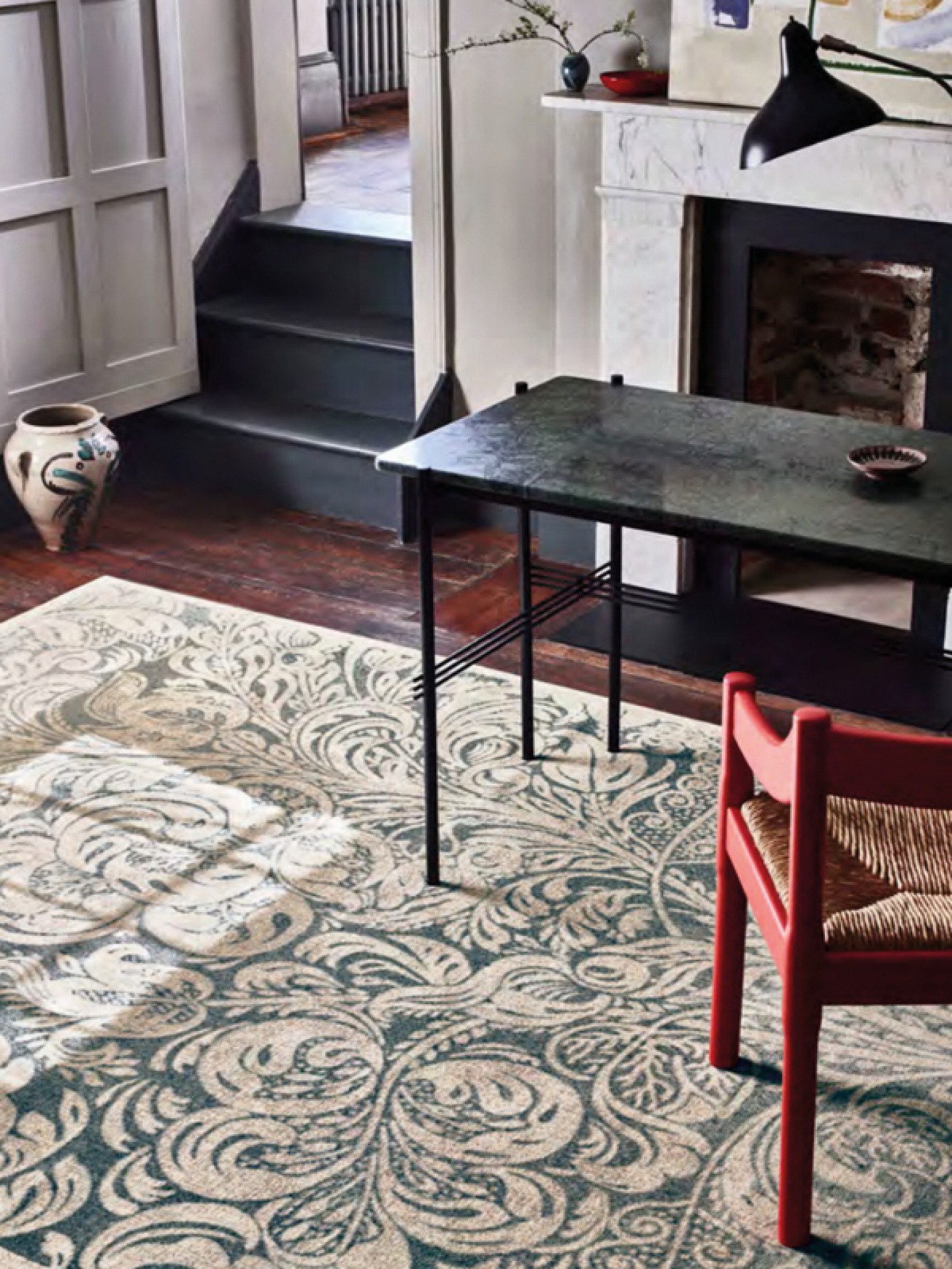 beige and teal patterned run, red chair and black table