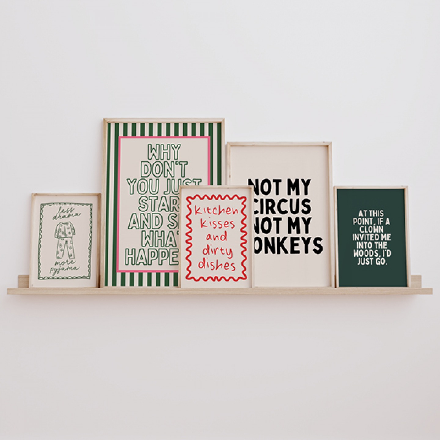 Framed slogan prints in varied sizes sitting on a shelf with neutral background