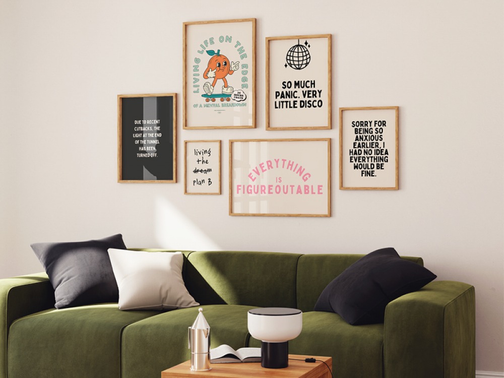 Framed prints above a green suede sofa