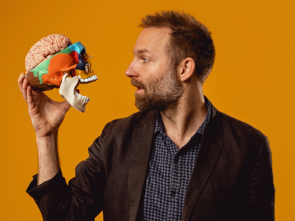 Benji Waterhouse holding a colourful skill with a brain in the top