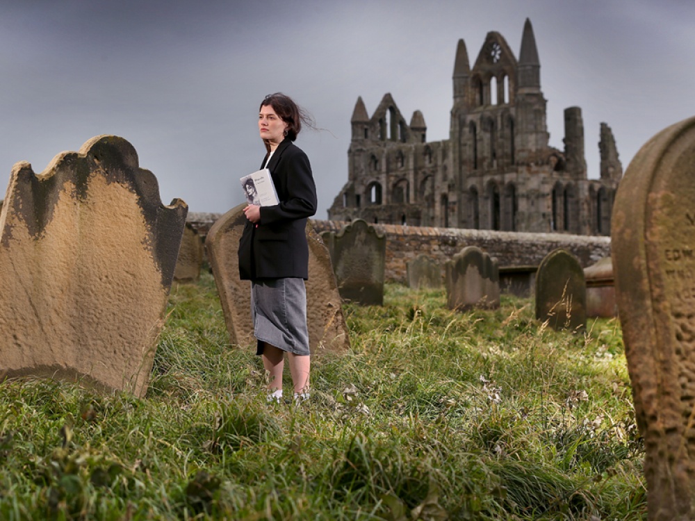 artist stood in a graveyard by an old abbey