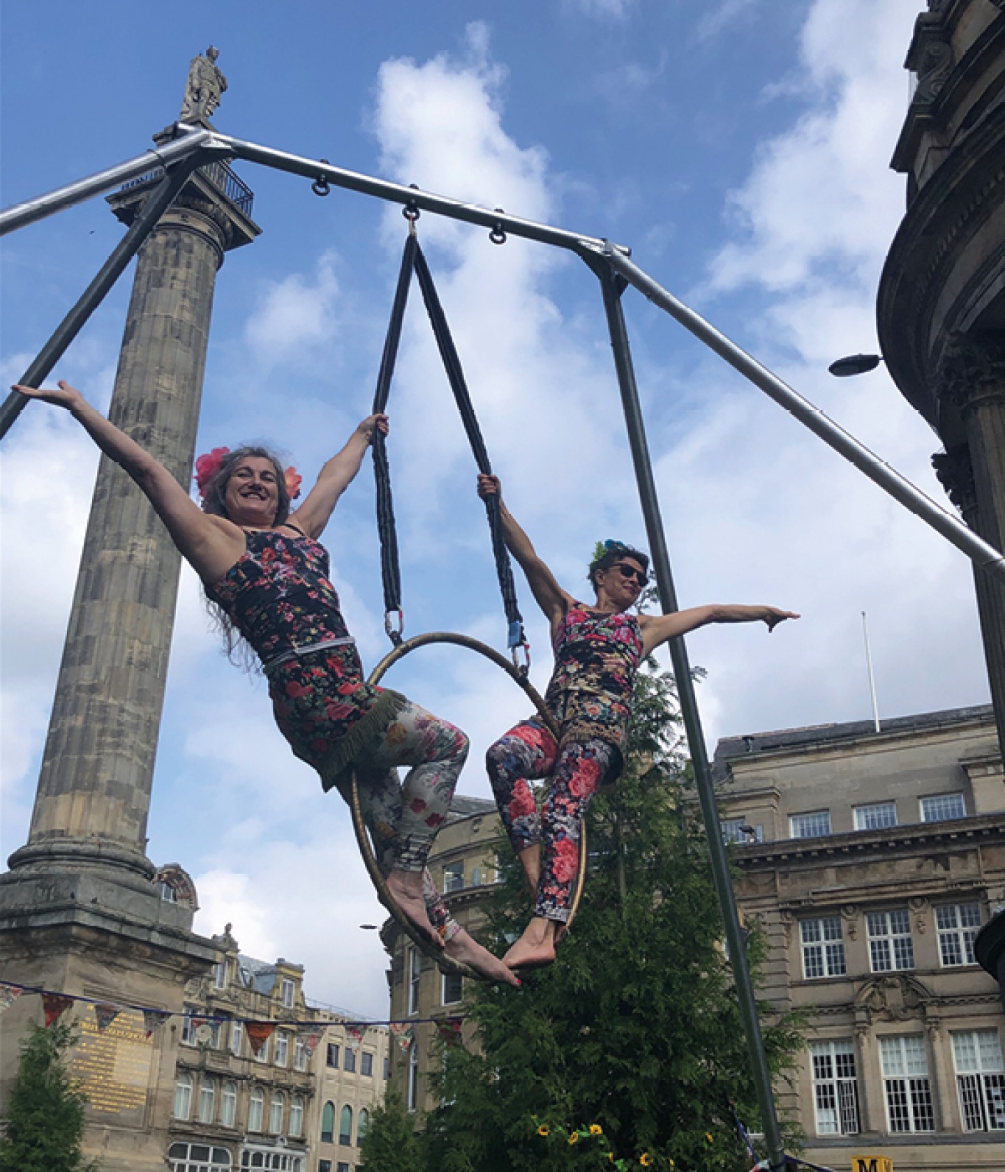 2 women street performing on aerialist ring