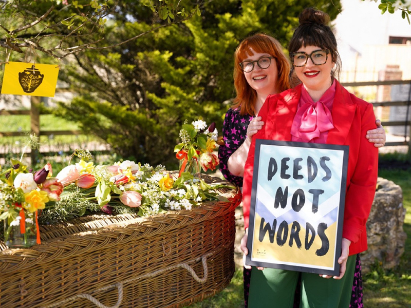 2 women standing together holding a framed typography print