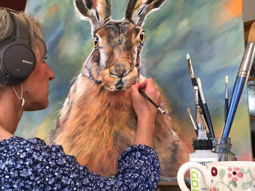 Vicki painting a piece of artwork