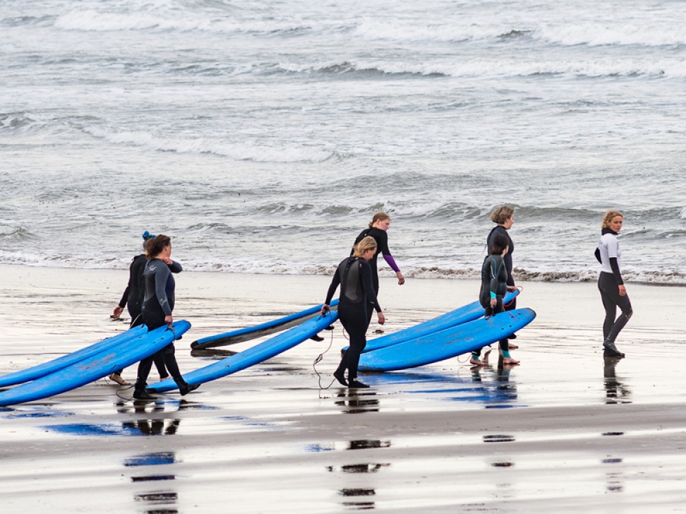 surfers walking towards the sea