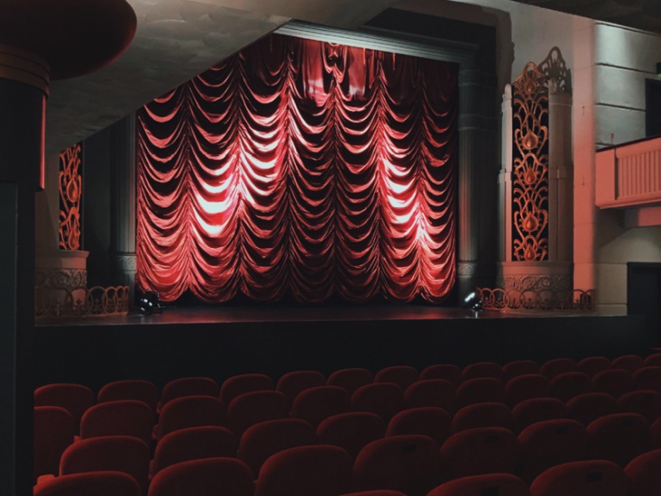 traditional theatre with red chairs and curtain