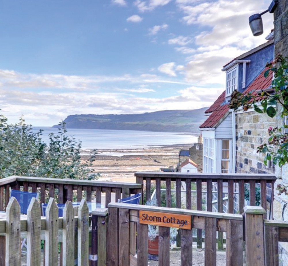 Stone cottage with wooden gate looking over the bay