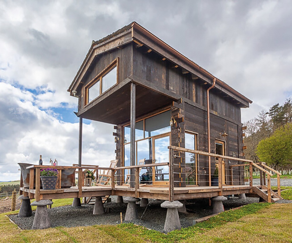 2 storey wooden hut with outdoor bad on the edge of the deck