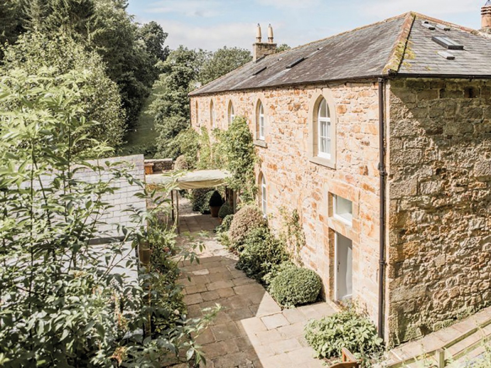 Brinkburn external shot of stone building with canopy and greenery