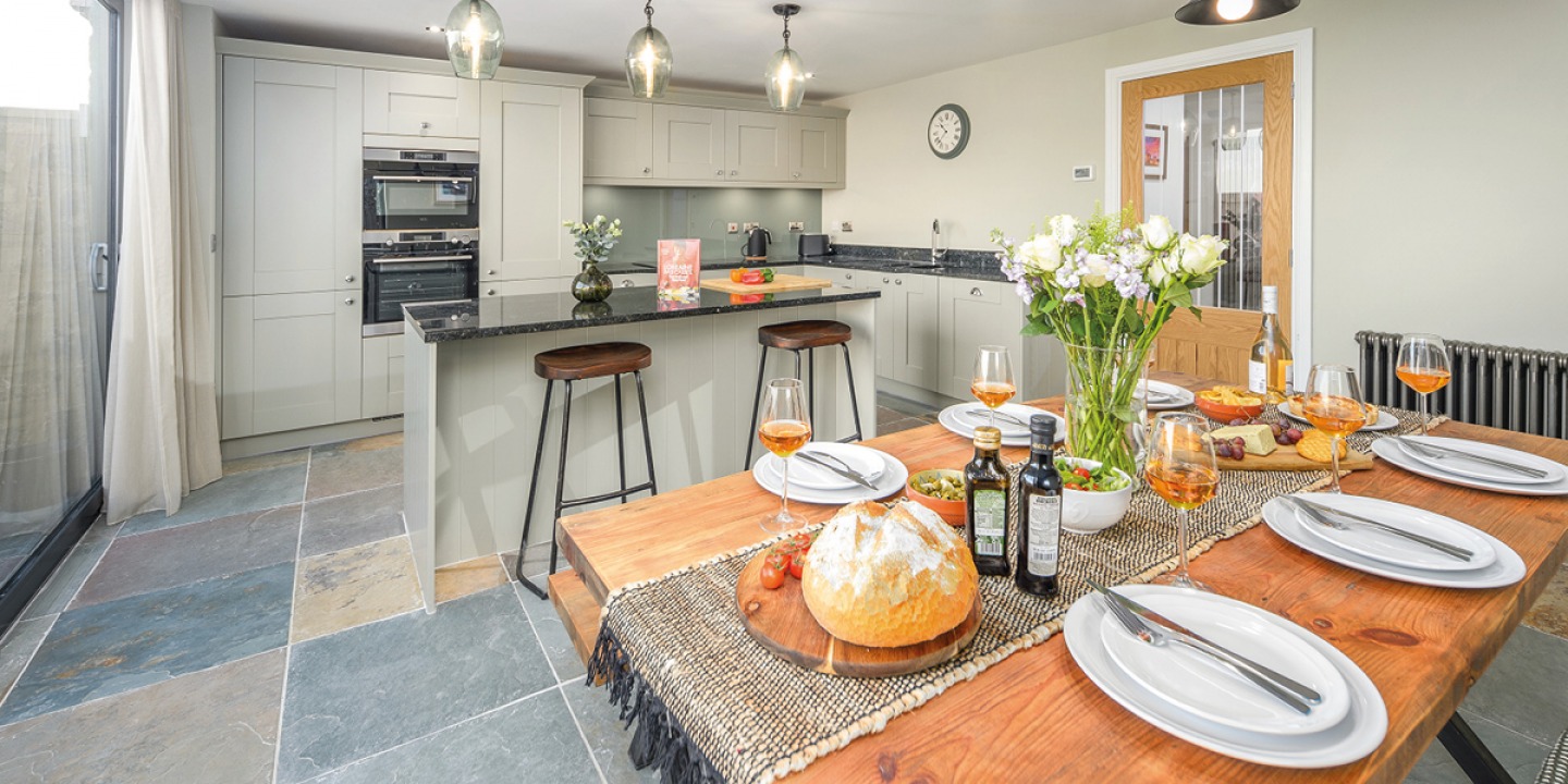 modern open plan kitchen dining area with set table and flowers