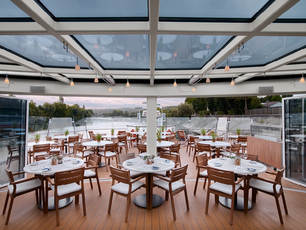 class ceiling canopy with tables and chairs looking out to the back of the boat