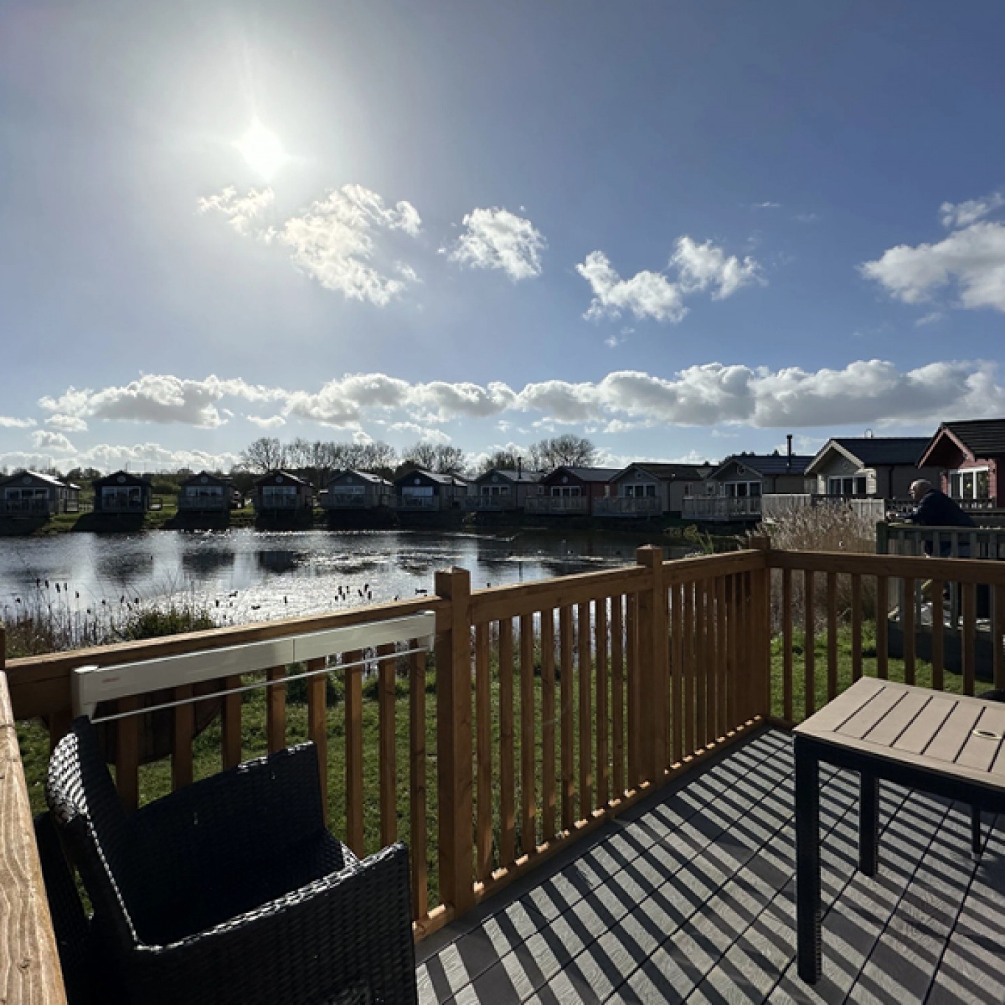 Wooden deck looking over a lake on a sunny day