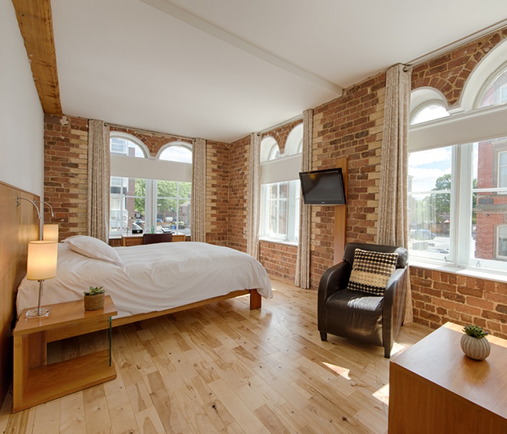 Exposed brick studio room with arched windows