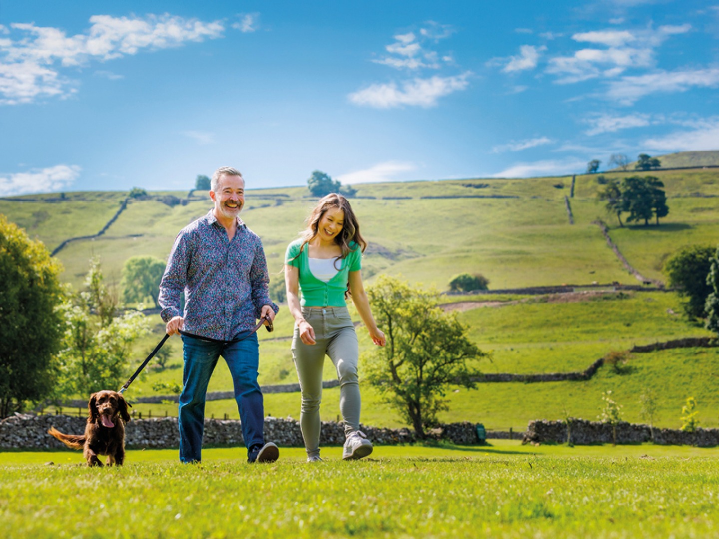 Couple walking dog in Yorkshire Dales