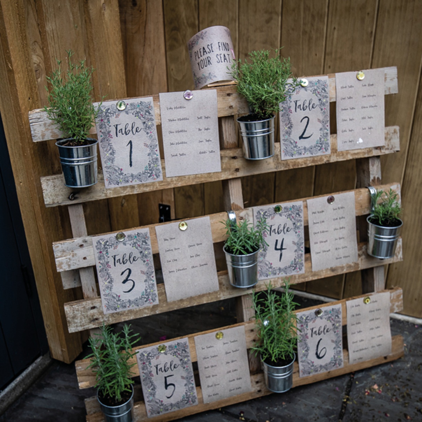 Table plan pinned to a wooden crate with metal plant pots