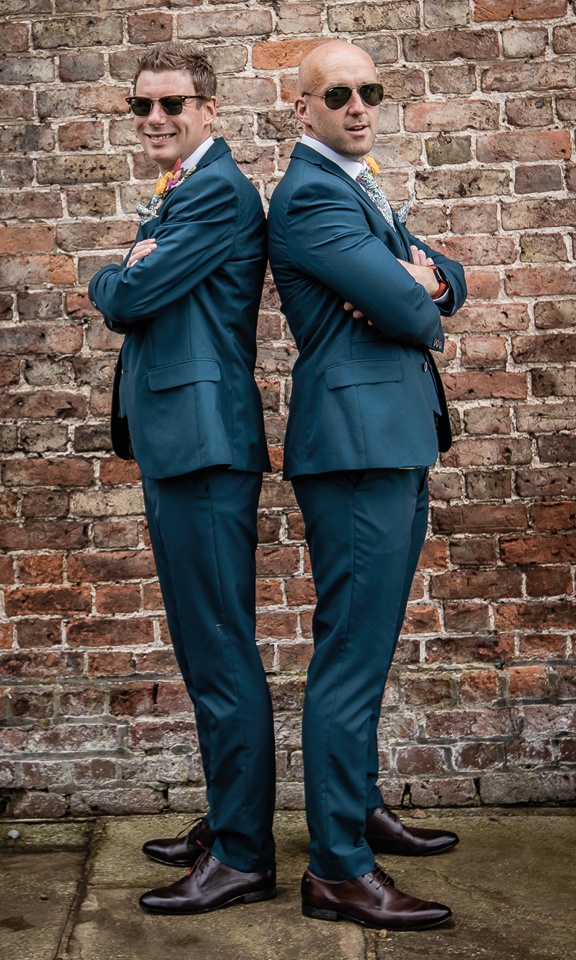 groom and best man standing back to back with folded arms