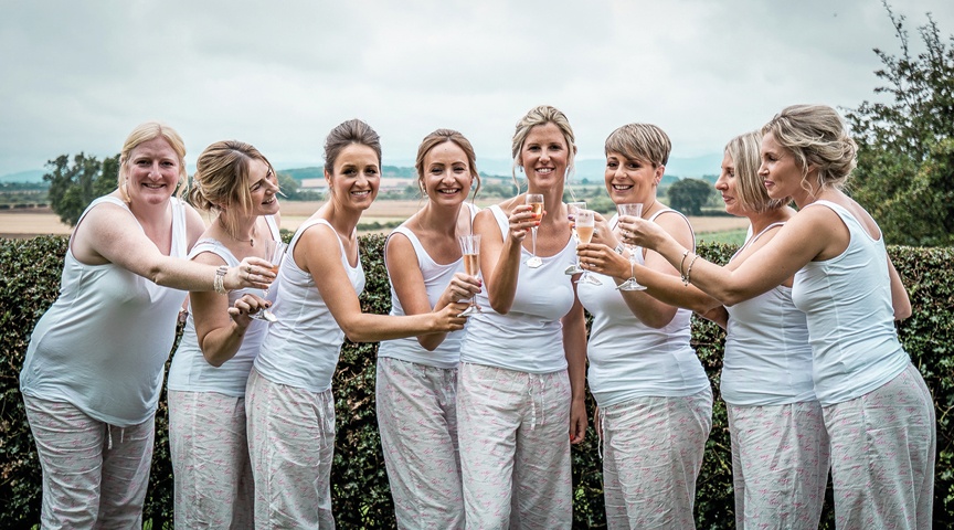 bridal party raising a glass on fizz in matching pyjamas