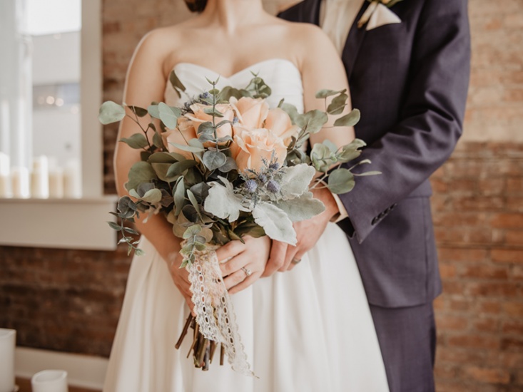 bride and groom with blush flowers