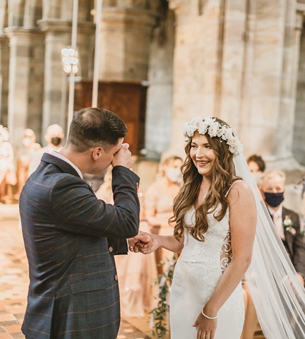 groom wiping eyes looking at bride during ceremony