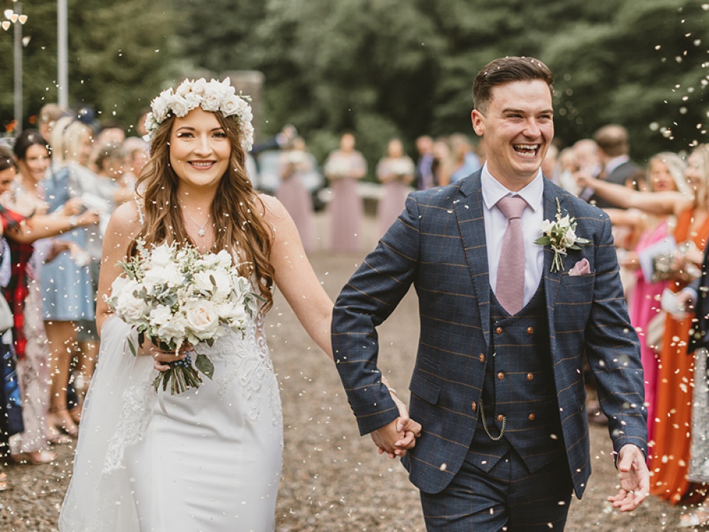 Bride and Groom walking between guests throwing confetti