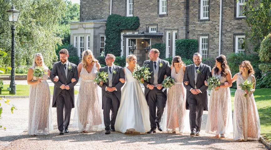 wedding party walking arm in arm