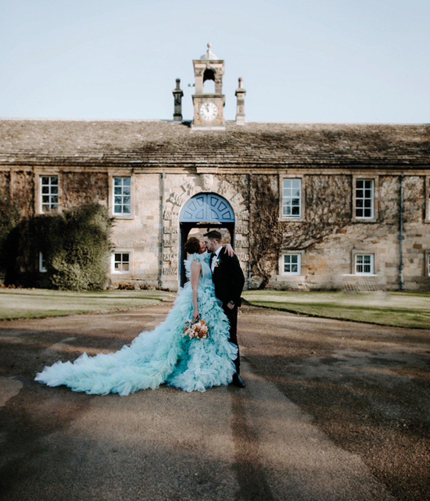 Bride and groom embracing in front of the venue