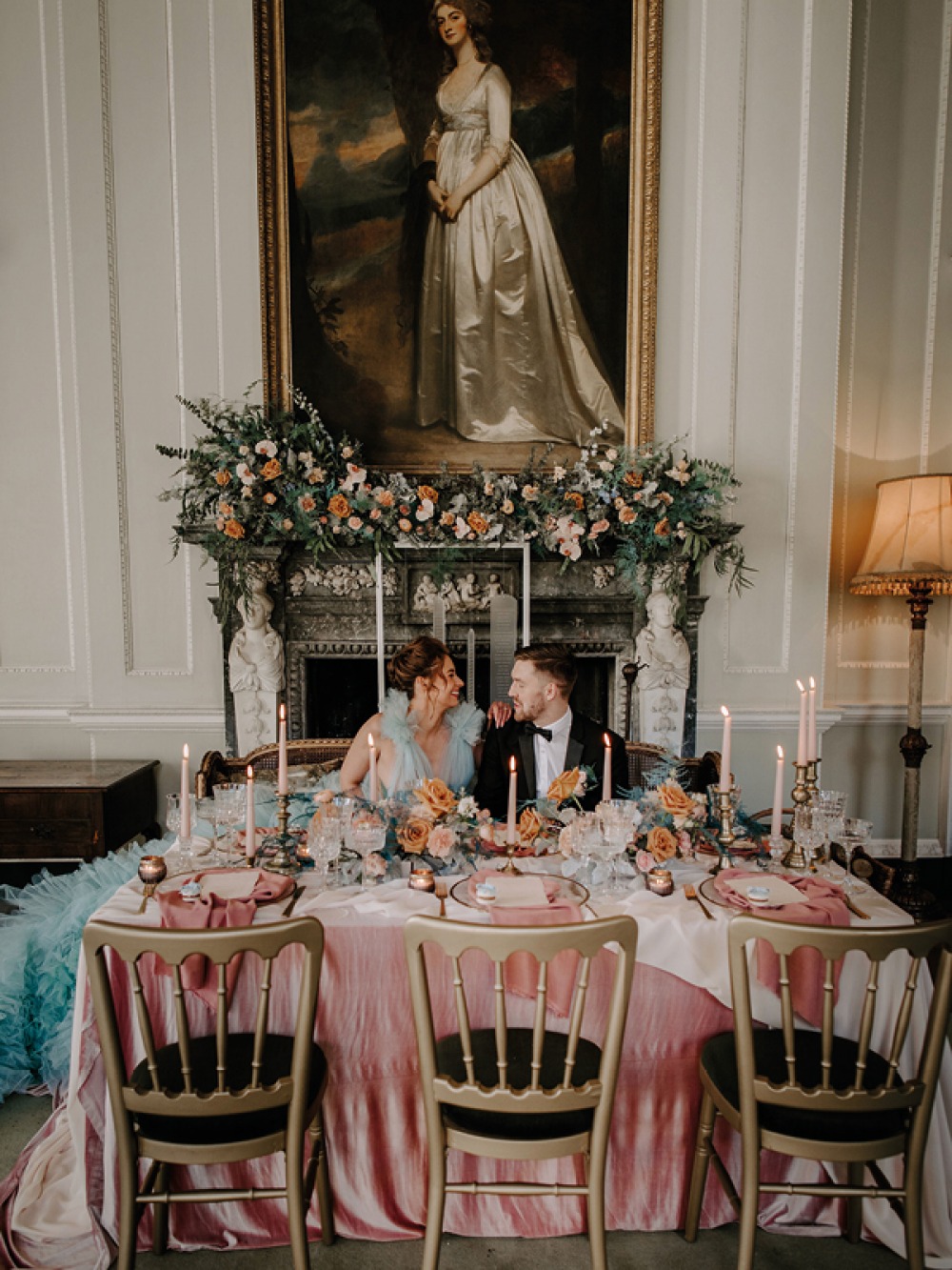 bride and groom sitting at set wedding table