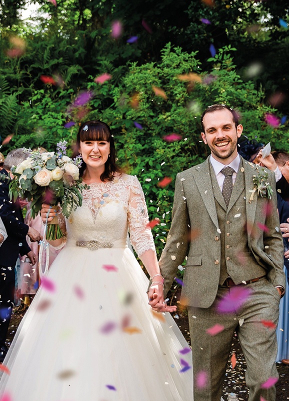 bride and groom surrounded by confetti