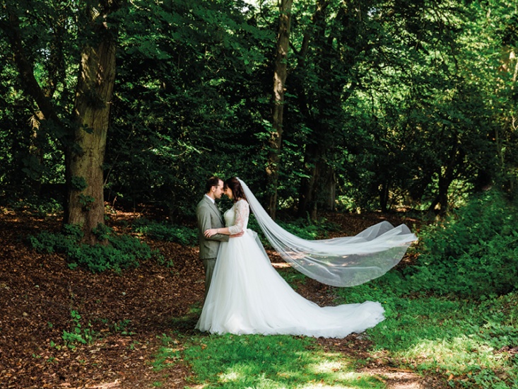 Bride and groom embracing in woodland