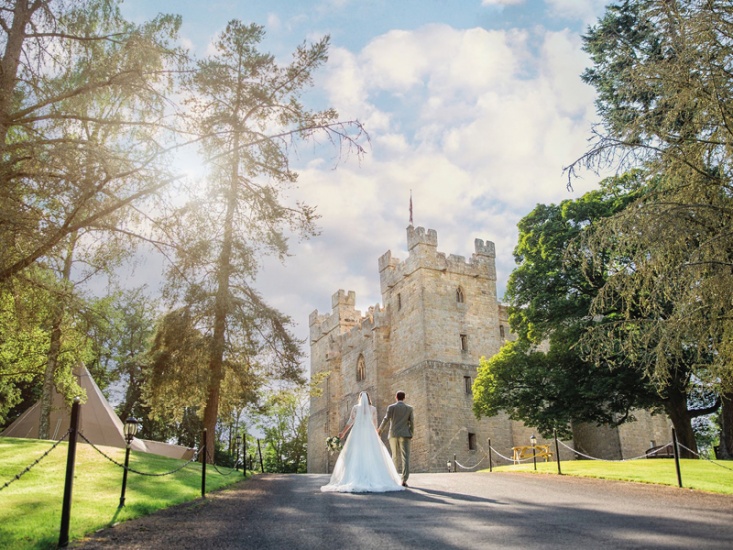 bride and groom walking away toward Langley Castle